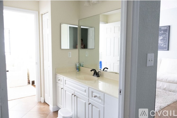 A bathroom with a white vanity and a mirror above it.