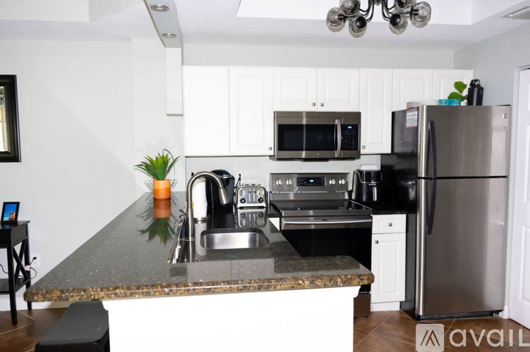 A kitchen with a granite countertop and stainless steel appliances.