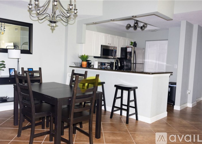 A kitchen with a black table and chairs.