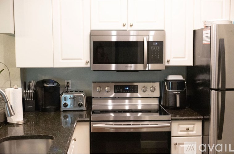 A kitchen with a toaster, microwave, oven, sink and refrigerator.