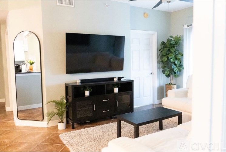 A living room with a black entertainment center and a white couch.