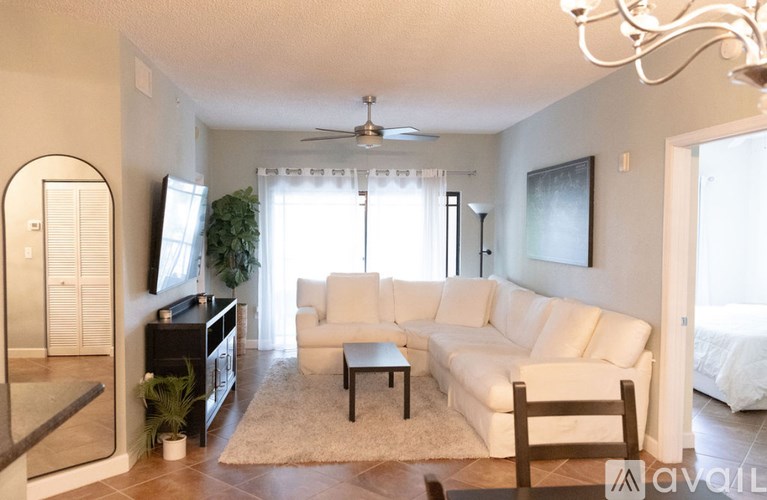 A living room with a white couch and a rug.