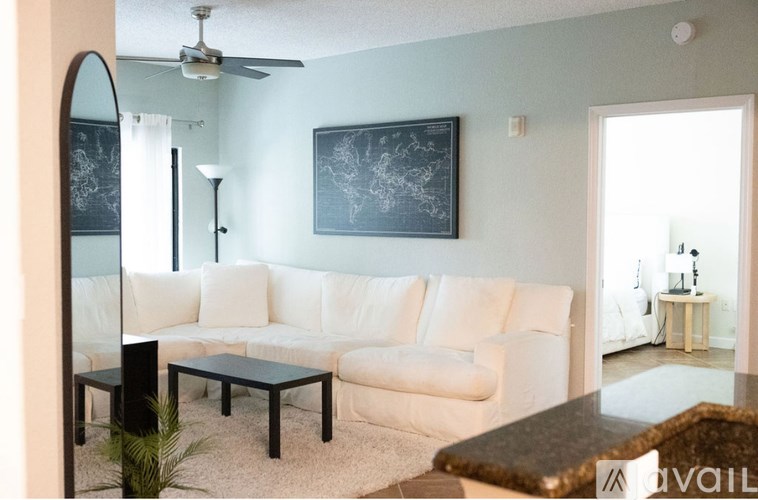 A living room with a white couch and a black coffee table.