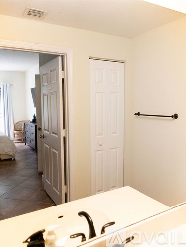 A white bathroom with a sink and a mirror.