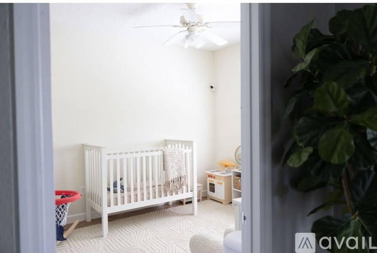A baby room with a crib and a fan.