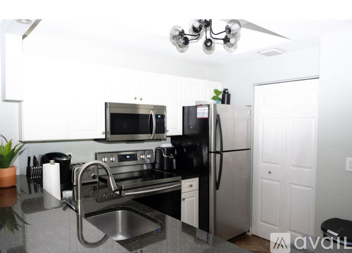A kitchen with a stainless steel refrigerator, microwave, and oven.