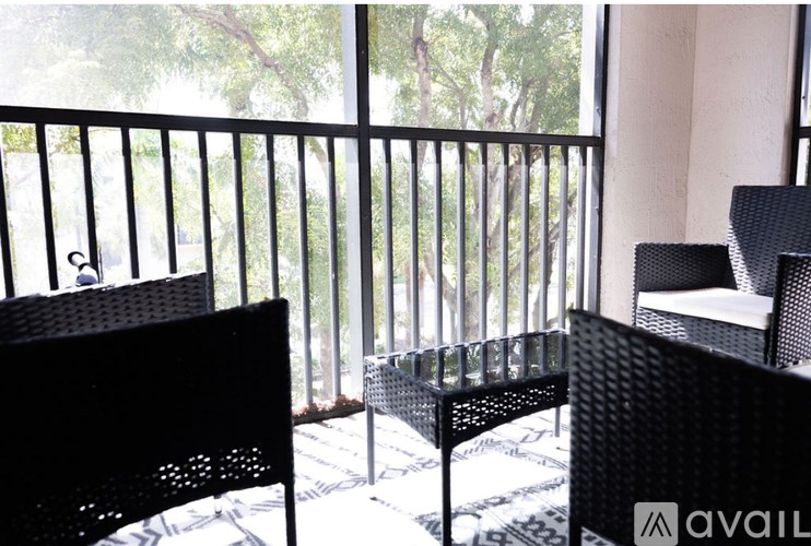 A balcony with two chairs and a table.