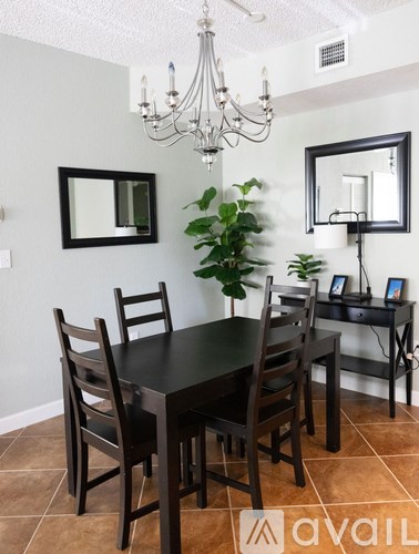 A dining room with a table and chairs.