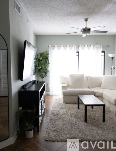 A living room with a black piano and a white couch.