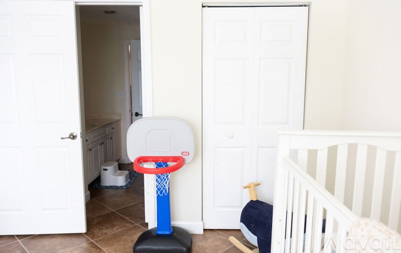 A baby's room with a crib and a basketball hoop.