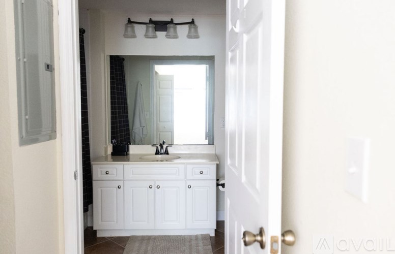 A white bathroom with a sink and mirror.
