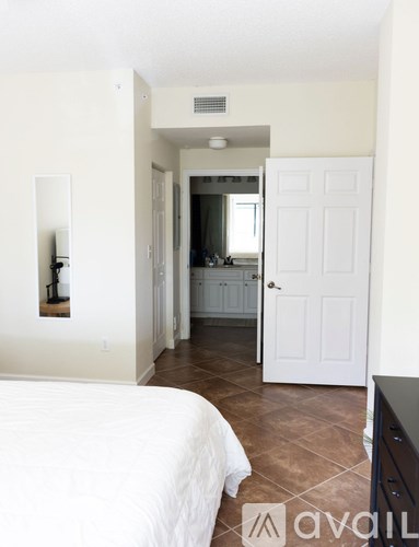 A bedroom with a bed, dresser and mirror.