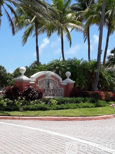 A bedroom with a white bed and a ceiling fan.