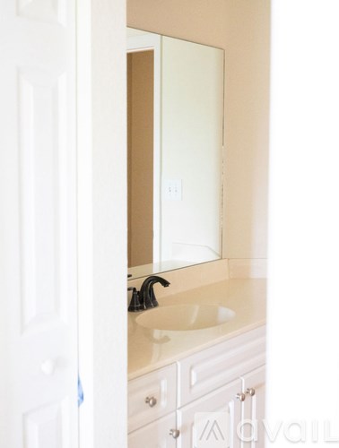 A white bathroom sink with a mirror above it.