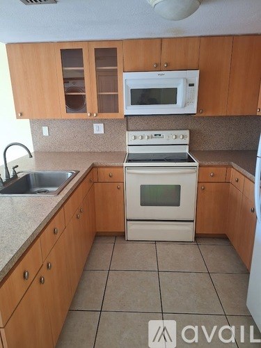 A kitchen with wooden cabinets and a white oven.