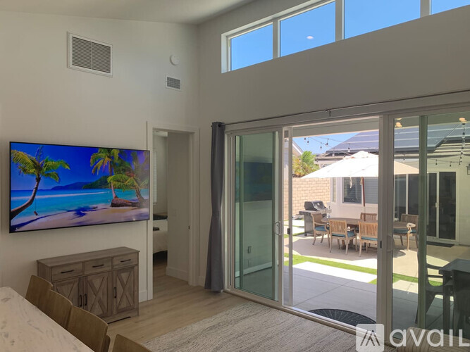 A living room with a large flat screen TV mounted on the wall.