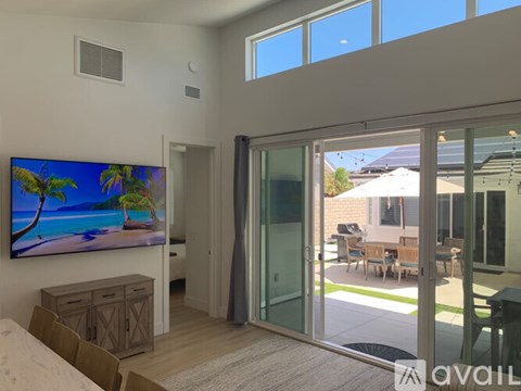 A living room with a large flat screen TV mounted on the wall.