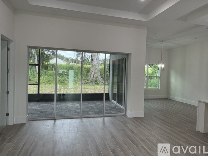 A spacious room with a view of the outdoors through large windows.