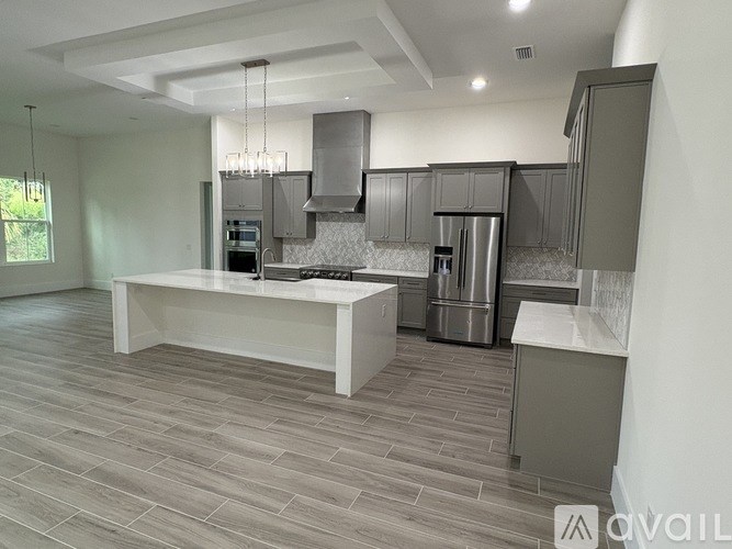 A modern kitchen with a large island and stainless steel appliances.