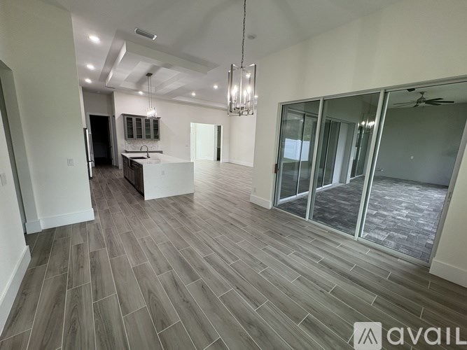 A spacious room with wooden flooring and a ceiling fan.