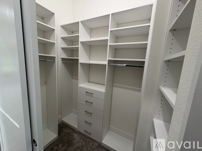 A white walk-in closet with shelves and drawers.
