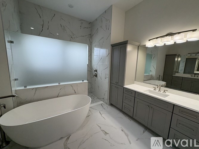 A bathroom with a marble floor and a white bathtub.