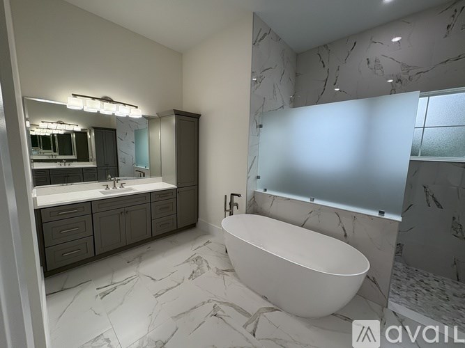 A modern bathroom with a marble patterned floor and a white bathtub.