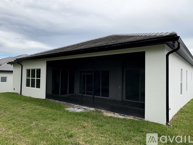A white building with black roof and windows is available for purchase.
