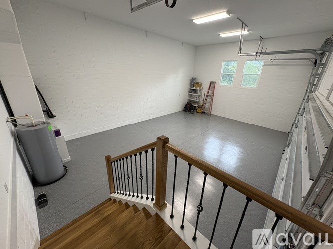 A spacious room with a staircase leading to the upper floor.