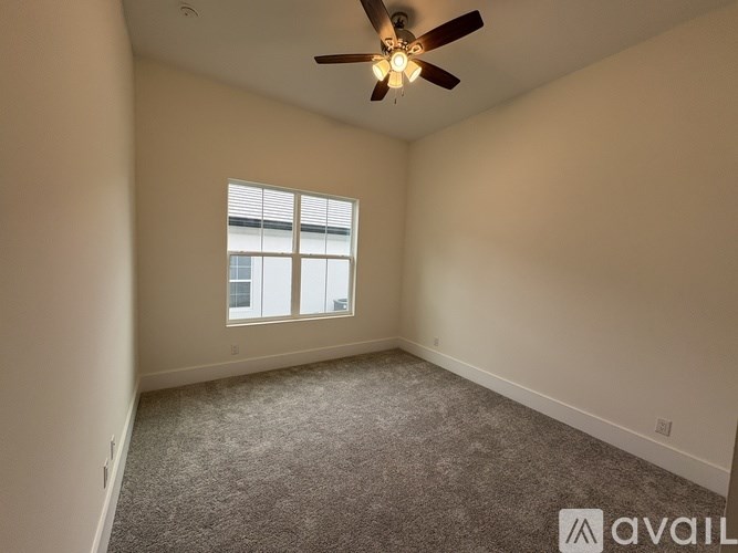 A room with a ceiling fan and a window.