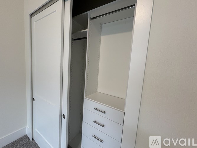 A white closet with a mirror and drawers is shown.