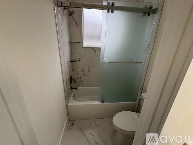 A small bathroom with a toilet and a walk-in shower.