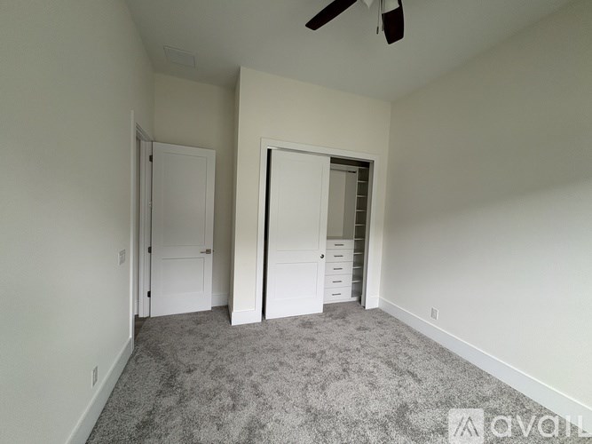 A room with a ceiling fan and two doors.