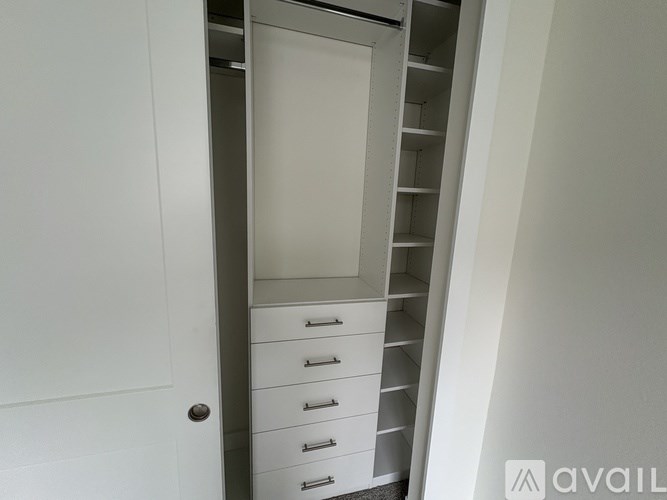 A white cabinet with drawers and shelves is open.