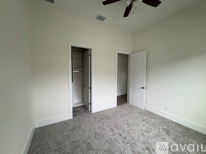 A room with a ceiling fan and two doors, one of which is open.