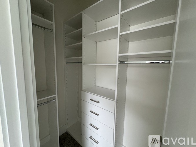 A white walk-in closet with shelves and drawers.