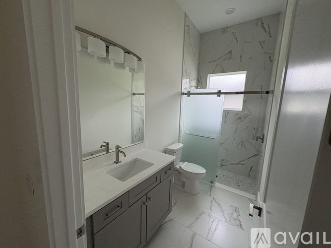 A bathroom with a sink, toilet, and shower.