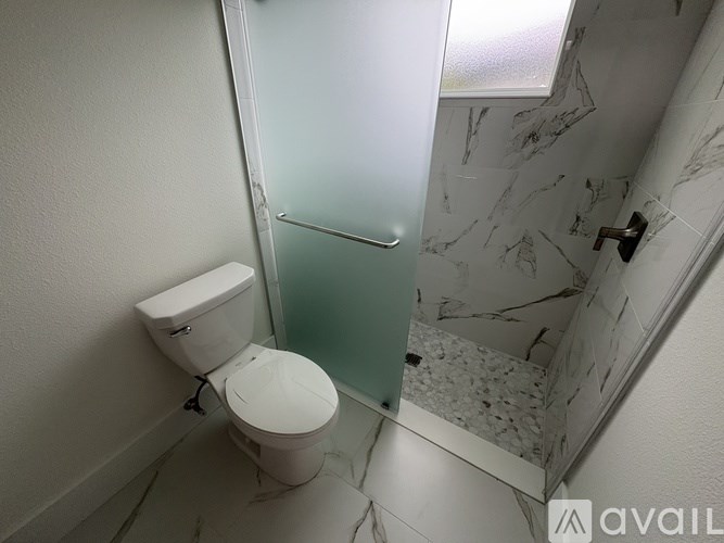 A white toilet in a bathroom with marble tiles.