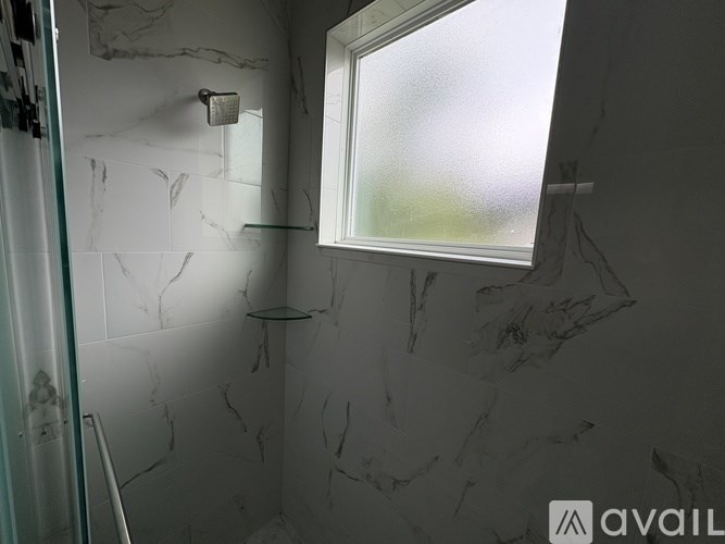 A bathroom with a marble wall and a window.