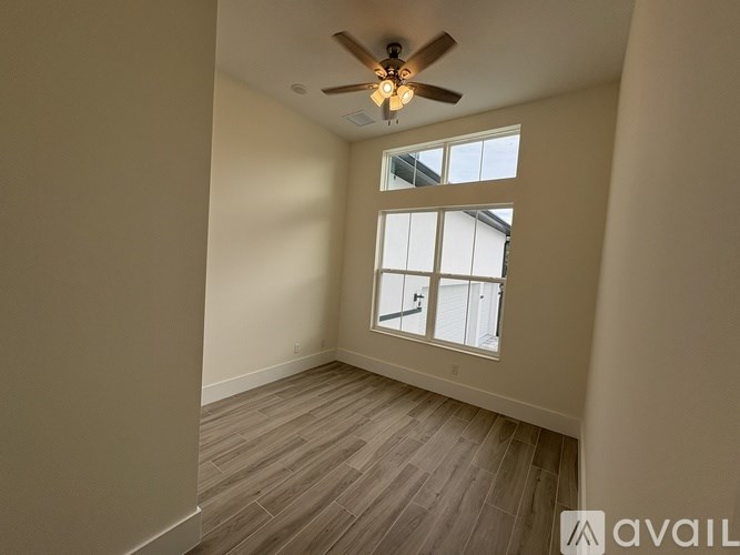 A room with a ceiling fan and a window.