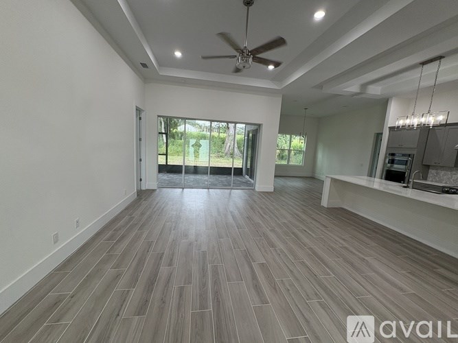 A spacious room with a ceiling fan and wooden flooring.