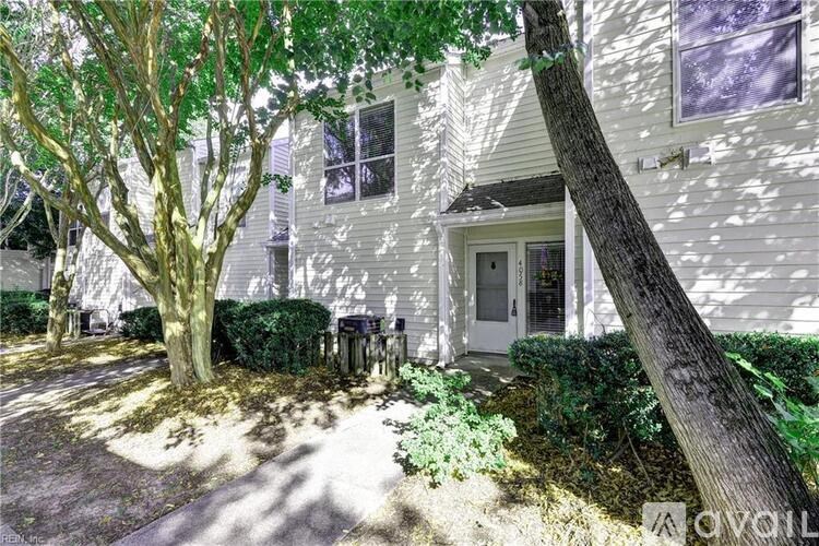 A white house with a tree in front of it.