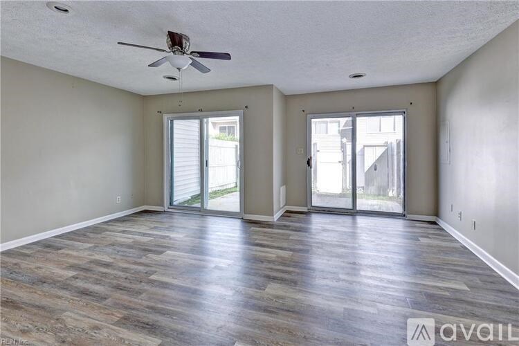 A spacious room with a ceiling fan and sliding glass doors.