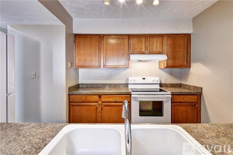 A kitchen with a white stove top oven and a white sink.
