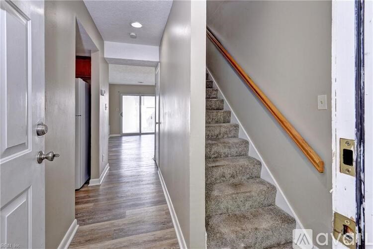 A hallway with a staircase leading to the second floor.