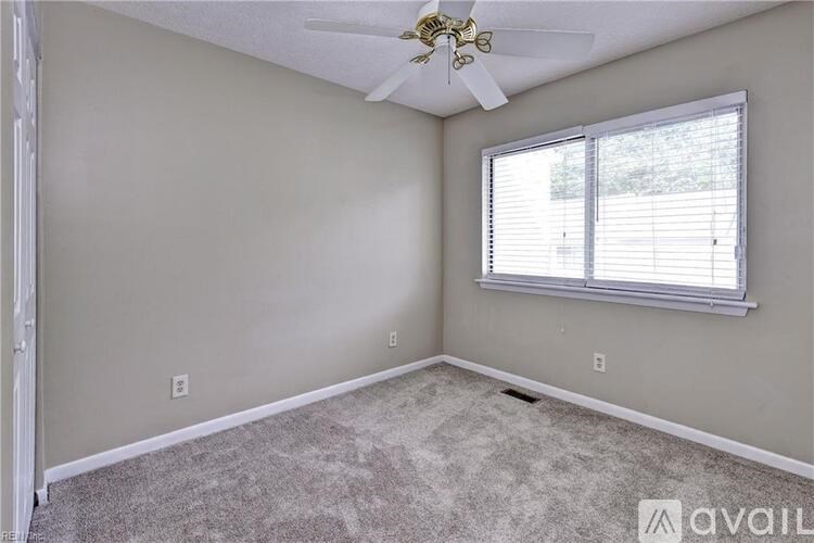 A room with a ceiling fan and a window with blinds.