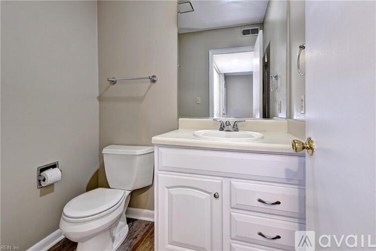 A white bathroom with a toilet, sink, and mirror.