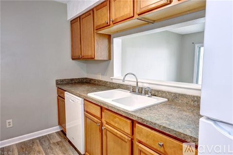 A kitchen with wooden cabinets and a white dishwasher.