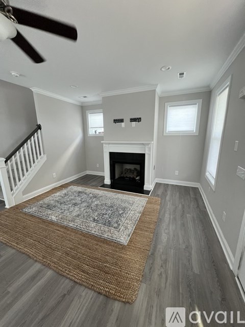 A living room with a fireplace and a rug on the floor.