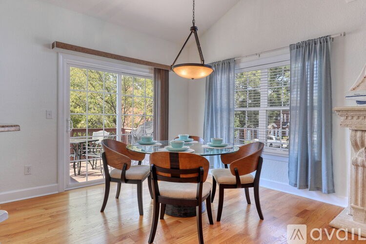 A dining room with a table set for four and a view of the backyard.